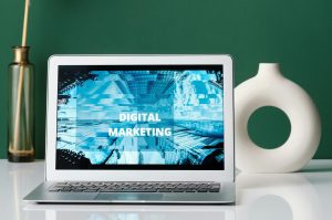 Digital Marketing text on the laptop, green wall background.